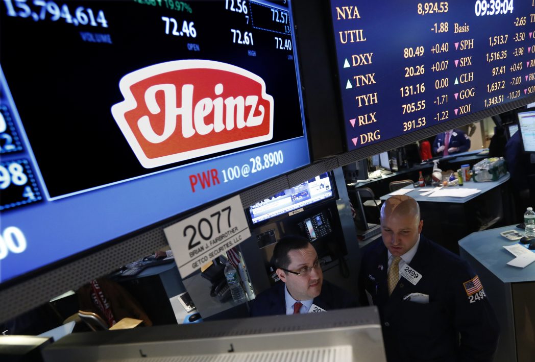 Traders work at the post that trades H.J. Heinz Co. on the floor of the New York Stock Exchange